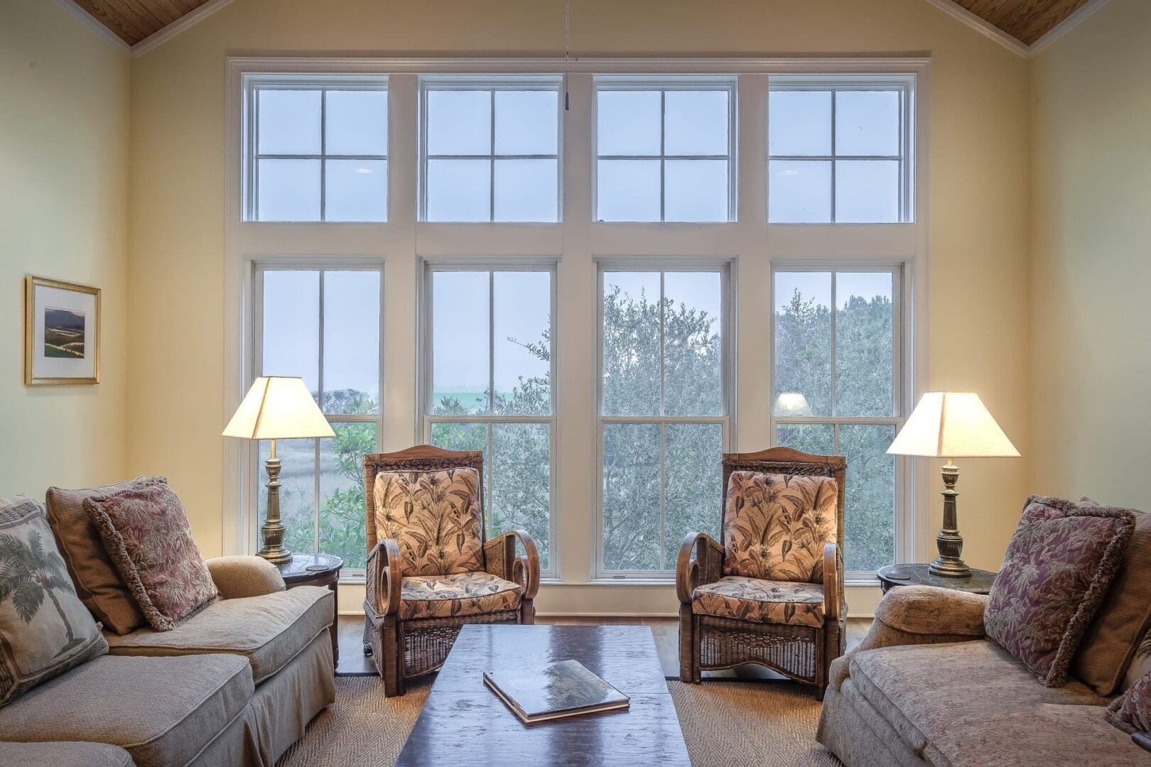 Cozy living room with two armchairs and large windows letting in natural light.